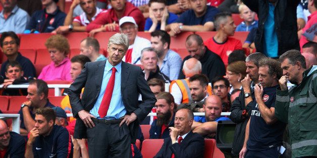 LONDON, ENGLAND - AUGUST 17: Arsene Wenger of Arsenal looks on as a fan behind makes his feelings known during the Barclays Premier League match between Arsenal and Aston Villa at Emirates Stadium on August 17, 2013 in London, England. (Photo by Clive Mason/Getty Images)