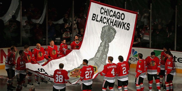 CHICAGO, IL - OCTOBER 01: Members of the Chicago Blackhawks watch as the 2013 Stanley Cup Championship banner is hung during a ceremony before taking on the Washington Capitals at the United Center on October 1, 2013 in Chicago, Illinois. (Photo by Jonathan Daniel/Getty Images)