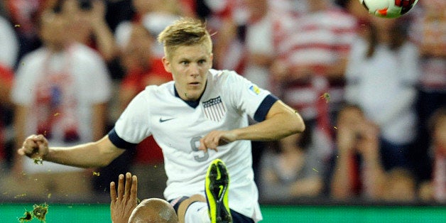 US forward Aron Johannsson kicks the ball past Jamaica midfielder Rudolph Austin during the US Men's National Team 2-0 win over Jamaica in a FIFA World Cup Qualifier at Sporting Park October 11, 2013 in Kansas City, Kansas. AFP PHOTO/DAVE KAUP (Photo credit should read DAVE KAUP/AFP/Getty Images)