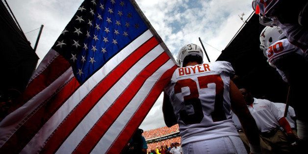 DALLAS, TX - OCTOBER 13: Nate Boyer #37 of the Texas Longhorns carries an American flag as the Texas Longhorns take to the field against the Oklahoma Sooners at Cotton Bowl on October 13, 2012 in Dallas, Texas. (Photo by Tom Pennington/Getty Images)