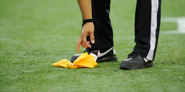MINNEAPOLIS, MN - OCTOBER 21: An official picks up a penalty flag from on the field during the game between the Minnesota Vikings and the Arizona Cardinals on October 21, 2012 at Mall of America Field at the Hubert H. Humphrey Metrodome in Minneapolis, Minnesota. (Photo by Hannah Foslien/Getty Images)