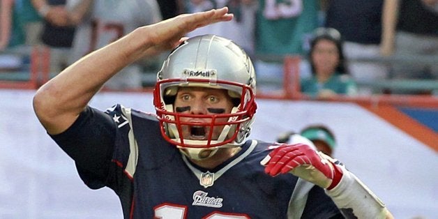 New England Patriots quarterback Tom Brady gives signals during an NFL game against the Miami Dolphins at Sun Life Stadium in