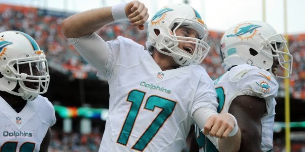 Miami Dolphins' Ryan Tannehill celebrates a touchdown to Mike Wallace in the second quarter against the New England Patriots