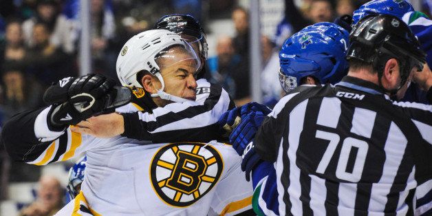 VANCOUVER, BC - DECEMBER 14: Officials hold back Dan Hamhuis #2 of the Vancouver Canucks and Jarome Iginla #12 of the Boston Bruins to stop their fight during an NHL game at Rogers Arena on December 14, 2013 in Vancouver, British Columbia, Canada. The Canucks defeated the Bruins 6-2. (Photo by Derek Leung/Getty Images)