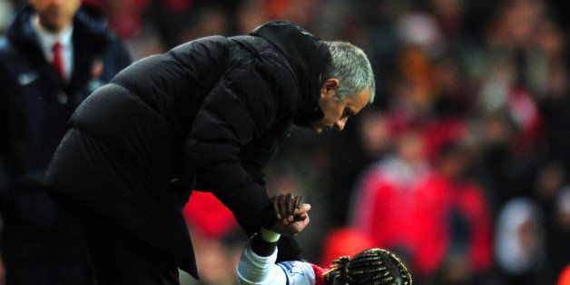LONDON, ENGLAND - DECEMBER 23: Jose Mourinho manager of Chelsea helps Bacary Sagna of Arsenal to his feet during the Barclays Premier League match between Arsenal and Chelsea at Emirates Stadium on December 23, 2013 in London, England. (Photo by Shaun Botterill/Getty Images)