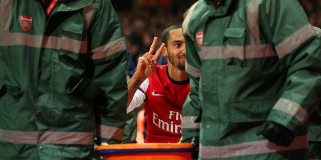 LONDON, ENGLAND - JANUARY 04: The injured Theo Walcott of Arsenal makes a 2-0 gesture to the Tottenham fans as he is stretch