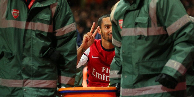 LONDON, ENGLAND - JANUARY 04: The injured Theo Walcott of Arsenal makes a 2-0 gesture to the Tottenham fans as he is stretchered off the pitch during the Budweiser FA Cup third round match between Arsenal and Tottenham Hotspur at Emirates Stadium on January 4, 2014 in London, England. (Photo by Clive Rose/Getty Images)