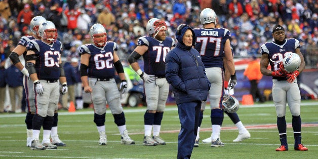 FOXBORO, MA - DECEMBER 8: Bill Belichick of the New England Patriots watches as Rob Gronkowski #87 is treated for injury in t