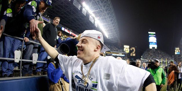 SEATTLE, WA - JANUARY 19: Rapper Macklemore celebrates after the Seattle Seahawks 23-17 victory against the San Francisco 49ers during the 2014 NFC Championship at CenturyLink Field on January 19, 2014 in Seattle, Washington. (Photo by Otto Greule Jr/Getty Images)
