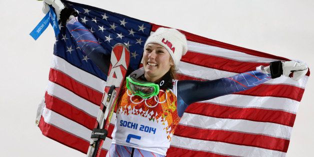 Women's slalom gold medal winner Mikaela Shiffrin of the United States poses for photographers with the U.S. flag at the Sochi 2014 Winter Olympics, Friday, Feb. 21, 2014, in Krasnaya Polyana, Russia.(AP Photo/Gero Breloer)