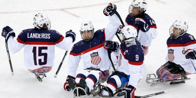 SOCHI, RUSSIA - MARCH 09: Adam Page of USA (2L) celebrates scoring his team's second goal during the Ice Sledge Hockey Preliminary Round Group B match between the USA and Korea at Shayba Arena on March 9, 2014 in Sochi, Russia. (Photo by Harry Engels/Getty Images)