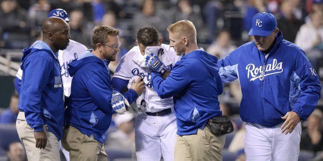 Kansas City Royals' Omar Infante (14) is helped off the field after being hit by a pitch from Tampa Bay Rays relief pitcher Heath Bell in the seventh inning during Monday's baseball game on April 7, 2014, at Kauffman Stadium in Kansas City, Mo. (John Sleezer/Kansas City Star/MCT via Getty Images)