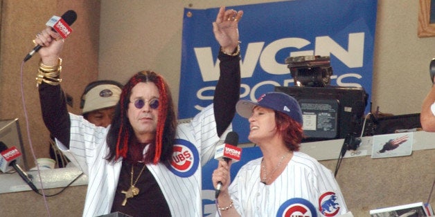 CHICAGO - AUGUST 17: Celebrity Ozzy Osbourne and his wife Sharon sing 'Take Me Out to the Ball Game' during the seventh inning stretch of a game between the Chicago Cubs and the Los Angeles Dodgers underneath a sign which pays tribute to the late former Cubs announcer Harry Caray on August 17, 2003 at Wrigley Field in Chicago, Illinois. The Dodgers defeated the Cubs 3-0. (Photo by Jonathan Daniel/Getty Images)