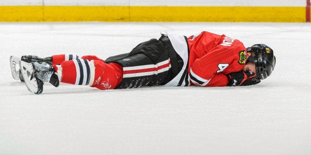 CHICAGO, IL - MAY 4: Niklas Hjalmarsson #4 of the Chicago Blackhawks lays on the ice after blocking a shot and getting hit with the puck in Game Two of the Second Round of the 2014 Stanley Cup Playoffs against the Minnesota Wild at the United Center on May 04, 2014 in Chicago, Illinois. (Photo by Bill Smith/NHLI via Getty Images)