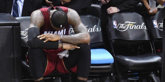 LeBron James of the Miami Heat sits on the sidelines after cramping up during Game 1 of the NBA Finals against the San Antonio Spurs, June 5, 2014 in San Antonio, Texas. The Spurs defeated the Heat 110-95, taking to lead the series 1-0. AFP PHOTO / Robyn Beck (Photo credit should read ROBYN BECK/AFP/Getty Images)