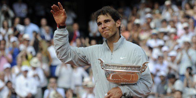 Spain's Rafael Nadal waves as he holds the Musketeers trophy after winning the French tennis Open men's final match against Serbia's Novak Djokovic at the Roland Garros stadium in Paris on June 8, 2014. AFP PHOTO / DOMINIQUE FAGET (Photo credit should read DOMINIQUE FAGET/AFP/Getty Images)