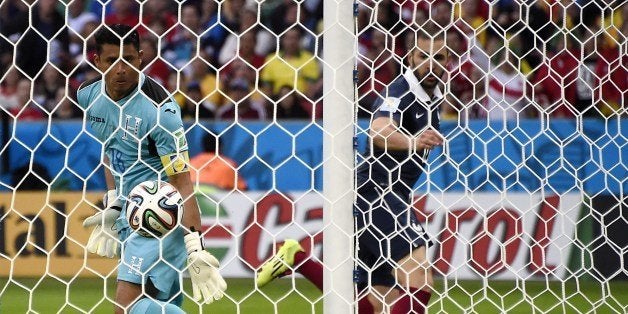 France's forward Karim Benzema (R) scores past Honduras' goalkeeper Luis Lopez during a Group E football match between Franc