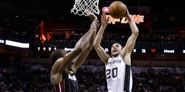 San Antonio Spurs guard Manu Ginobili (20) goes in for a dunk over Miami Heat center Chris Bosh (1) during the first half in Game 5 of the NBA basketball finals on Sunday, June 15, 2014, in San Antonio. (AP Photo/David J. Phillip)