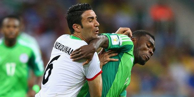 CURITIBA, BRAZIL - JUNE 16: Javad Nekounam of Iran competes for the ball with Emmanuel Emenike of Nigeria during the 2014 FIFA World Cup Brazil Group F match between Iran and Nigeria at Arena da Baixada on June 16, 2014 in Curitiba, Brazil. (Photo by Jamie Squire/Getty Images)