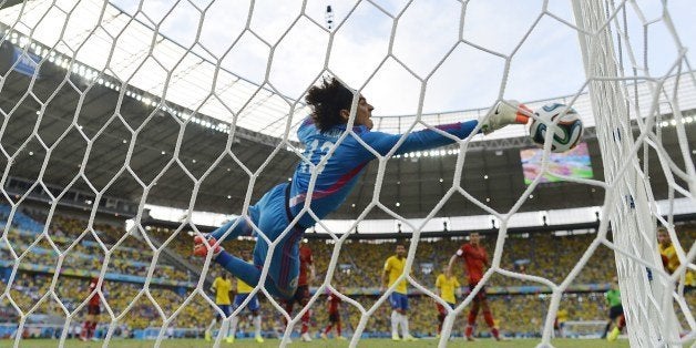 Mexico's goalkeeper Guillermo Ochoa dives for the ball during a Group A football match between Brazil and Mexico in the Caste