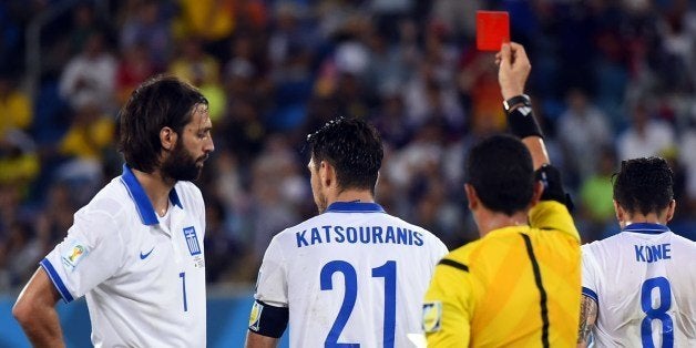 Greece's midfielder Kostas Katsouranis (C) is given the red card after a foul on Japan's midfielder Makoto Hasebe during a Gr
