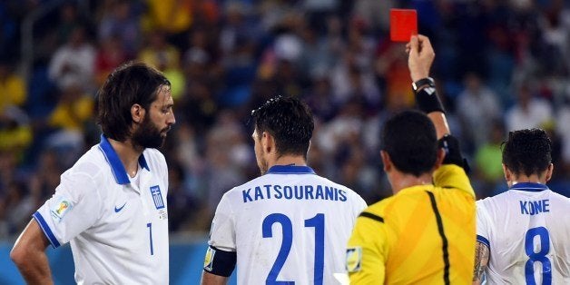 Greece's midfielder Kostas Katsouranis (C) is given the red card after a foul on Japan's midfielder Makoto Hasebe during a Group C football match between Japan and Greece at the Dunas Arena in Natal during the 2014 FIFA World Cup on June 19, 2014. AFP PHOTO / FABRICE COFFRINI (Photo credit should read FABRICE COFFRINI/AFP/Getty Images)