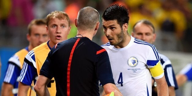 CUIABA, BRAZIL - JUNE 21: Emir Spahic of Bosnia and Herzegovina protests to assistant referee during the 2014 FIFA World Cup