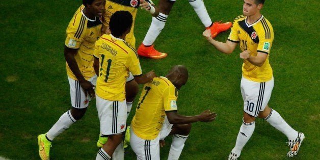 Colombia's midfielder James Rodriguez (R) is mobbed by teammates as he celebrates his second goal during the Round of 16 football match between Colombia and Uruguay at The Maracana Stadium in Rio de Janeiro on June 28, 2014,during the 2014 FIFA World Cup. AFP PHOTO / FABRIZIO BENSCH/POOL (Photo credit should read FABRIZIO BENSCH/AFP/Getty Images)