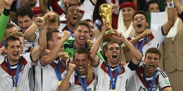 Germany's defender and captain Philipp Lahm (front-R) holds up the World Cup trophy as he celebrates on with his teammates af