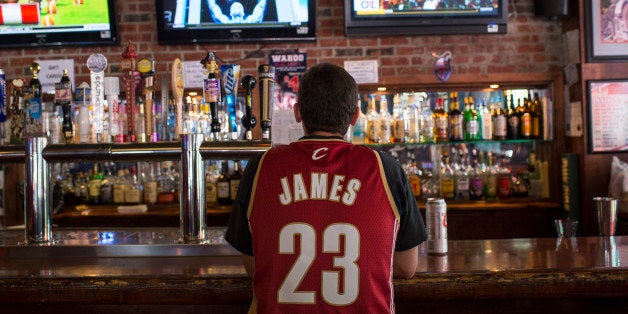 CLEVELAND, OH - JULY 11: A Cleveland Cavaliers fan wearing a Lebron James jersey watches news coverage of LeBron James return
