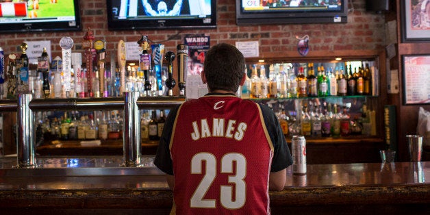 CLEVELAND, OH - JULY 11: A Cleveland Cavaliers fan wearing a Lebron James jersey watches news coverage of LeBron James return to Cleveland at Panini's Bar and Grille in downtown Cleveland on July 11, 2014 in Cleveland, Ohio (Photo by Angelo Merendino/Getty Images)