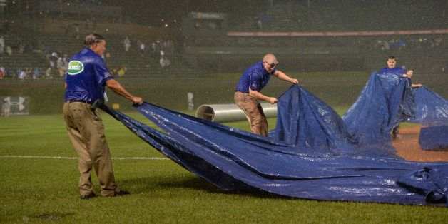 CHICAGO, IL - AUGUST 19: The Chicago Cubs ground crew struggles to get the tarp on the field as heavy rain falls during the fifth inning of the Chicago Cubs game against the San Francisco Giants at Wrigley Field on August 19, 2014 in Chicago, Illinois. The game was initially called off resulting in a 2-0 Cubs win, but Major League Baseball accepted the Giant's protest and ruled the game suspended and the remaining portion of the game to be completed. (Photo by Brian D. Kersey/Getty Images) 