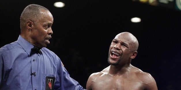 Referee Kenny Bayless holds back Floyd Mayweather Jr. of the US as he reacts accusing Marcos Maidana of Argentina on September 13, 2014 at The MGM Grand, Las Vegas. Mayweather dominated with a 12 round unanimous decision over Maidana retaining his WBA Welterweight Belt and WBC Welterweight and Super Welterweight World Titles. (Photo John Gurzinski / AFP) (Photo credit should read JOHN GURZINSKI/AFP/Getty Images)