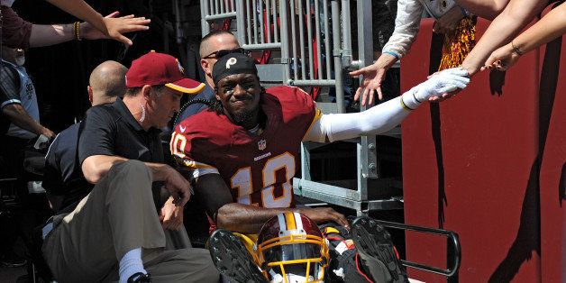 LANDOVER, MD - SEPTEMBER 14: Quarterback Robert Griffin III #10 of the Washington Redskins is carted off the field after being injured in the first quarter against the Jacksonville Jaguars at FedExField on September 14, 2014 in Landover, Maryland. (Photo by Patrick Smith/Getty Images)