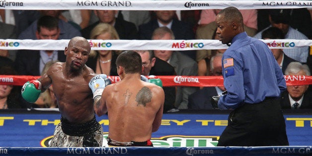 LAS VEGAS, NV - SEPTEMBER 13: Floyd Mayweather Jr. (L) jabs at Marcos Maidana as referee Kenny Bayless watches, during their