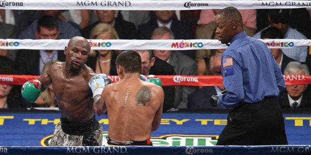 LAS VEGAS, NV - SEPTEMBER 13: Floyd Mayweather Jr. (L) jabs at Marcos Maidana as referee Kenny Bayless watches, during their WBC/WBA welterweight title fight at the MGM Grand Garden Arena on September 13, 2014 in Las Vegas, Nevada. (Photo by Alex Menendez/Getty Images)