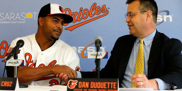 Baltimore Orioles Executive Vice-President of Baseball Operations Dan Duquette, right, shakes hands with Nelson Cruz tafter introducing him to the media during a news conference at the Ed Smith Stadium complex before the team's baseball spring training workout in Sarasota, Fla., Tuesday, Feb. 25, 2014. (AP Photo/Gene J. Puskar)