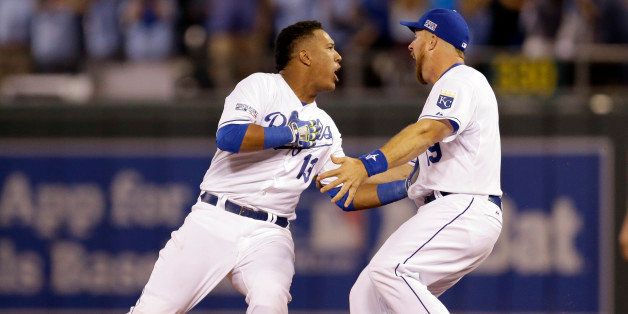 Kansas City Royals' Salvador Perez, left, is congratulated by Erik Kratz after hitting a walk-off single in the 12th inning to defeat the Oakland Athletics 9-8 in the AL wild-card playoff baseball game Tuesday, Sept. 30, 2014, in Kansas City, Mo. (AP Photo/Jeff Roberson)