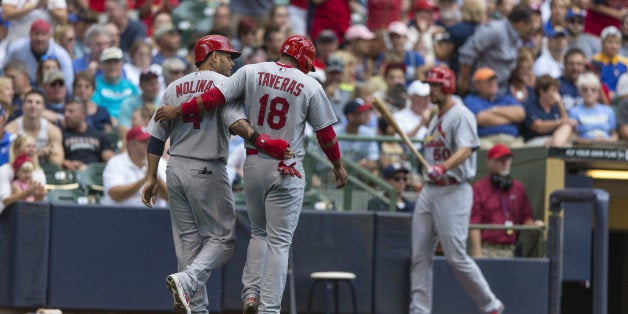 MILWAUKEE, WI - SEPTEMBER 7: Oscar Taveras #18 of the St. Louis Cardinals and teammate Yadier Molina #4 walk off the field af
