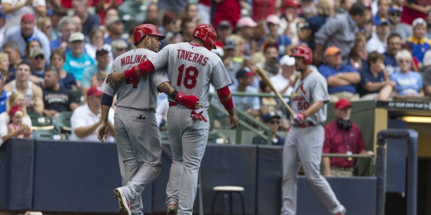 MILWAUKEE, WI - SEPTEMBER 7: Oscar Taveras #18 of the St. Louis Cardinals and teammate Yadier Molina #4 walk off the field after scoring against the Milwaukee Brewers at Miller Park on September 7, 2014 in Milwaukee, Wisconsin. (Photo by Tom Lynn/Getty Images)