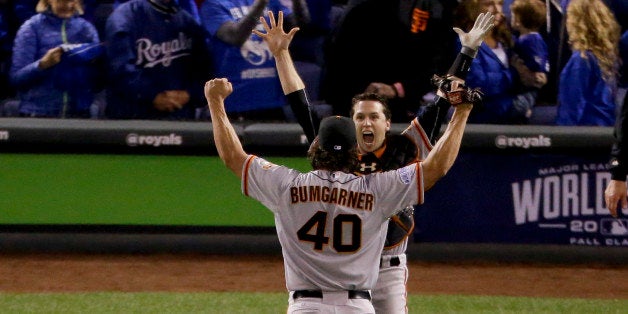 San Francisco Giants starting pitcher Madison Bumgarner, left, and catcher Buster Posey celebrate 3-2 win against the Kansas City Royals in Game 7 of baseball's World Series Wednesday, Oct. 29, 2014, in Kansas City, Mo. (AP Photo/Charlie Riedel)