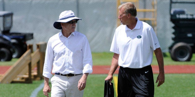 New York Jets owner Woody Johnson, left, talks with general manager John Idzik at their NFL football training camp Friday, July 26, 2013, in Cortland, N.Y. (AP Photo/Bill Kostroun)