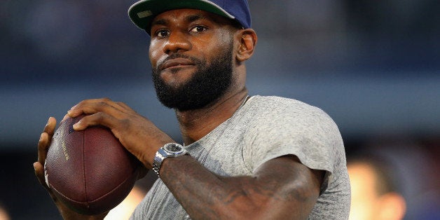 ARLINGTON, TX - SEPTEMBER 08: NBA player Lebron James of the Miami Heat throws a football at AT&T Stadium before a Sunday ni