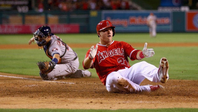 ANAHEIM, CA - SEPTEMBER 12: Mike Trout #27 of the Los Angeles Angels of Anaheim slides safely past catcher Jason Castro #15 of the Houston Astros at Angel Stadium of Anaheim on September 12, 2014 in Anaheim, California. (Photo by Jeff Gross/Getty Images) 