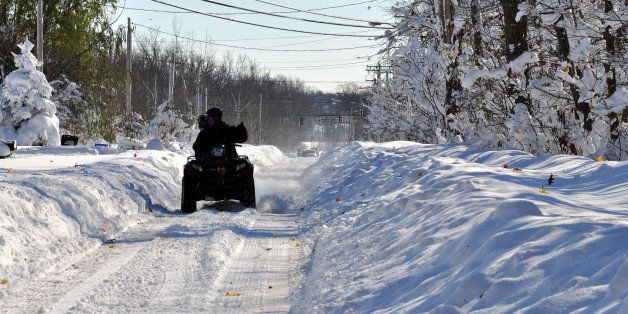 BUFFALO, NY - NOVEMBER 19, 2014: A four wheeler attempts to make his way through nearly five feet of snow on November 19, 2014 in the Lakeview neighborhood of Buffalo, New York. The record setting Lake effect snowstorm dumped up to six feet of snow in less than 24 hours closing a one hundred mile section of The New York State Thruway as well as other major roads around Buffalo. Four deaths have already been attributed to the storm and a second round beginning late Wednesday evening will bring up to three more feet of snow overnight. (Photo by John Normile/Getty Images)