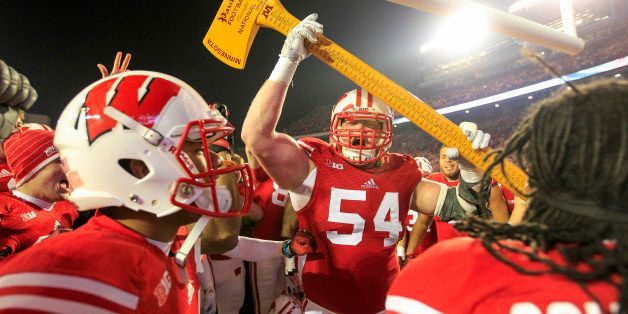 Wisconsin's Kyle Costigan (54) celebrates with the Paul Bunyan Axe trophy after Wisconsin beat Minnesota 34-24 in an NCAA college football game Saturday, Nov. 29, 2014, in Madison, Wis. (AP Photo/Andy Manis)