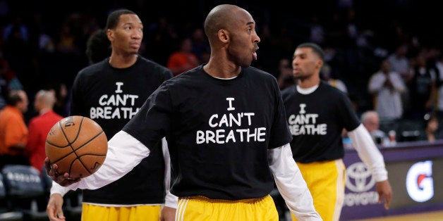 Los Angeles Lakers' Kobe Bryant, center, and his teammates warm up before an NBA basketball game against the Sacramento Kings, Tuesday, Dec. 9, 2014, in Los Angeles. Several athletes have worn "I Can't Breathe" shirts during warm ups in support of the family of Eric Garner, who died July 17 after a police officer placed him in a chokehold when he was being arrested for selling loose, untaxed cigarettes. (AP Photo/Jae C. Hong)