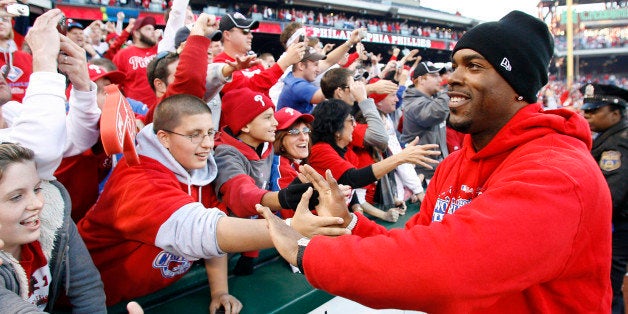 Philadelphia Phillies' Jimmy Rollins hi-fives fans lining the field at Citizen's Bank park at the end of the celebration of their World Series Championship, Friday, Oct. 31, 2008, in Philadelphia. (AP Photo/Tom Mihalek)