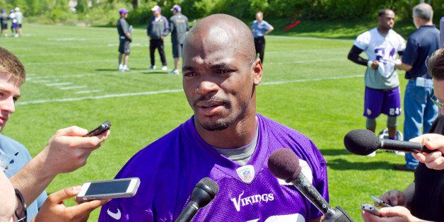 Minnesota Vikings running back Adrian Peterson (28) talks with reporters at the end of an NFL organized team activity at the Vikings football practice facility in Eden Prairie, Minn., Thursday, May 29, 2014.(AP Photo/Andy Clayton-King)