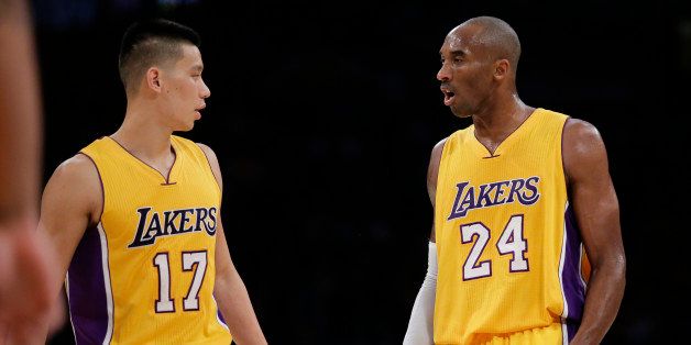 Los Angeles Lakers' Kobe Bryant, right, talks to Jeremy Lin during the first half of an NBA basketball game Tuesday, Dec. 9, 2014, in Los Angeles. (AP Photo/Jae C. Hong)